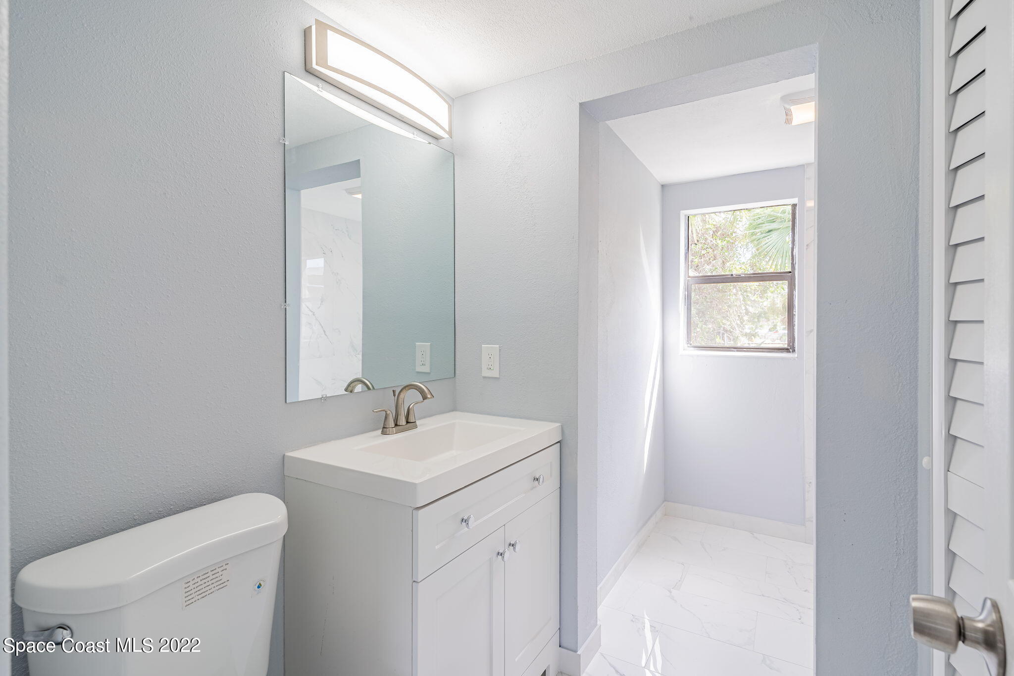 302 Prospect Avenue Cocoa, FL 32922 - Photo 20 of 28 a bathroom with a toilet sink and mirror