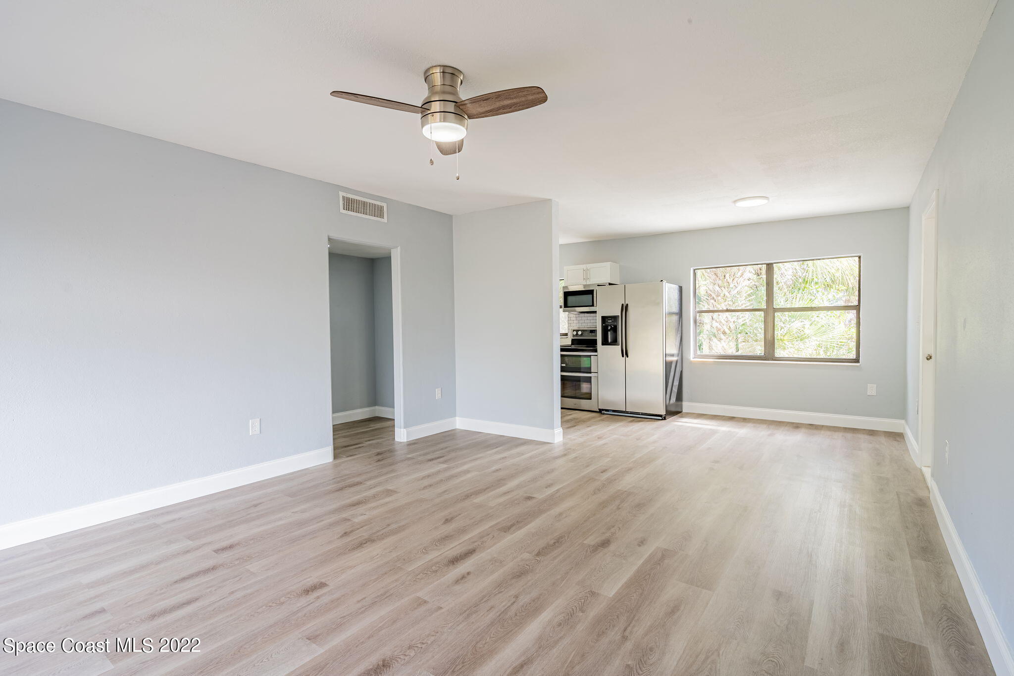 302 Prospect Avenue Cocoa, FL 32922 - Photo 6 of 28 an empty room with wooden floor chandelier and windows