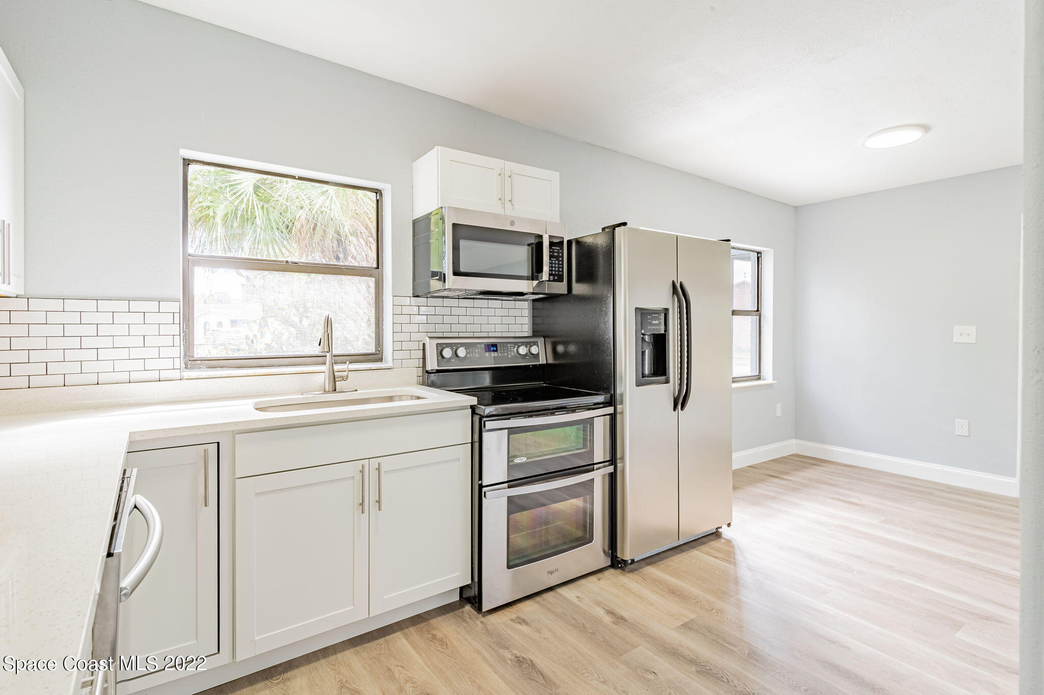 302 Prospect Avenue Cocoa, FL 32922 - Photo 10 of 28 a kitchen with stainless steel appliances granite countertop a stove a sink and a refrigerator