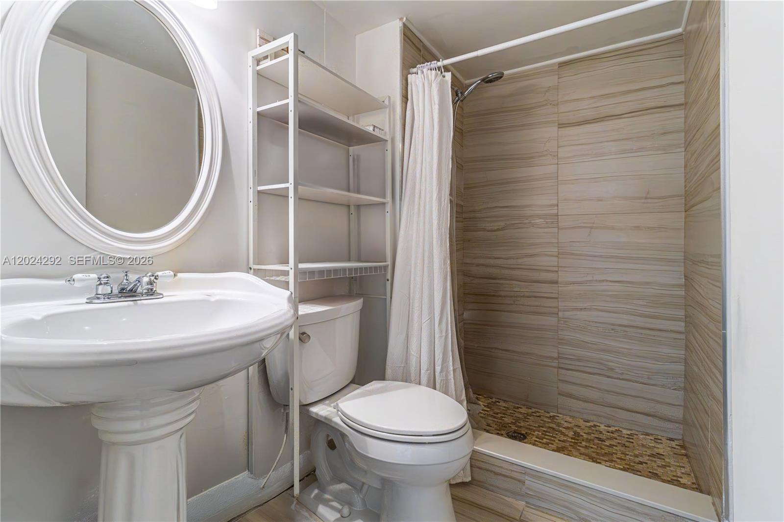 9780 Marina Boulevard, Unit 424 Boca Raton, FL 33428 - Photo 18 of 32 a bathroom with a sink toilet and shower