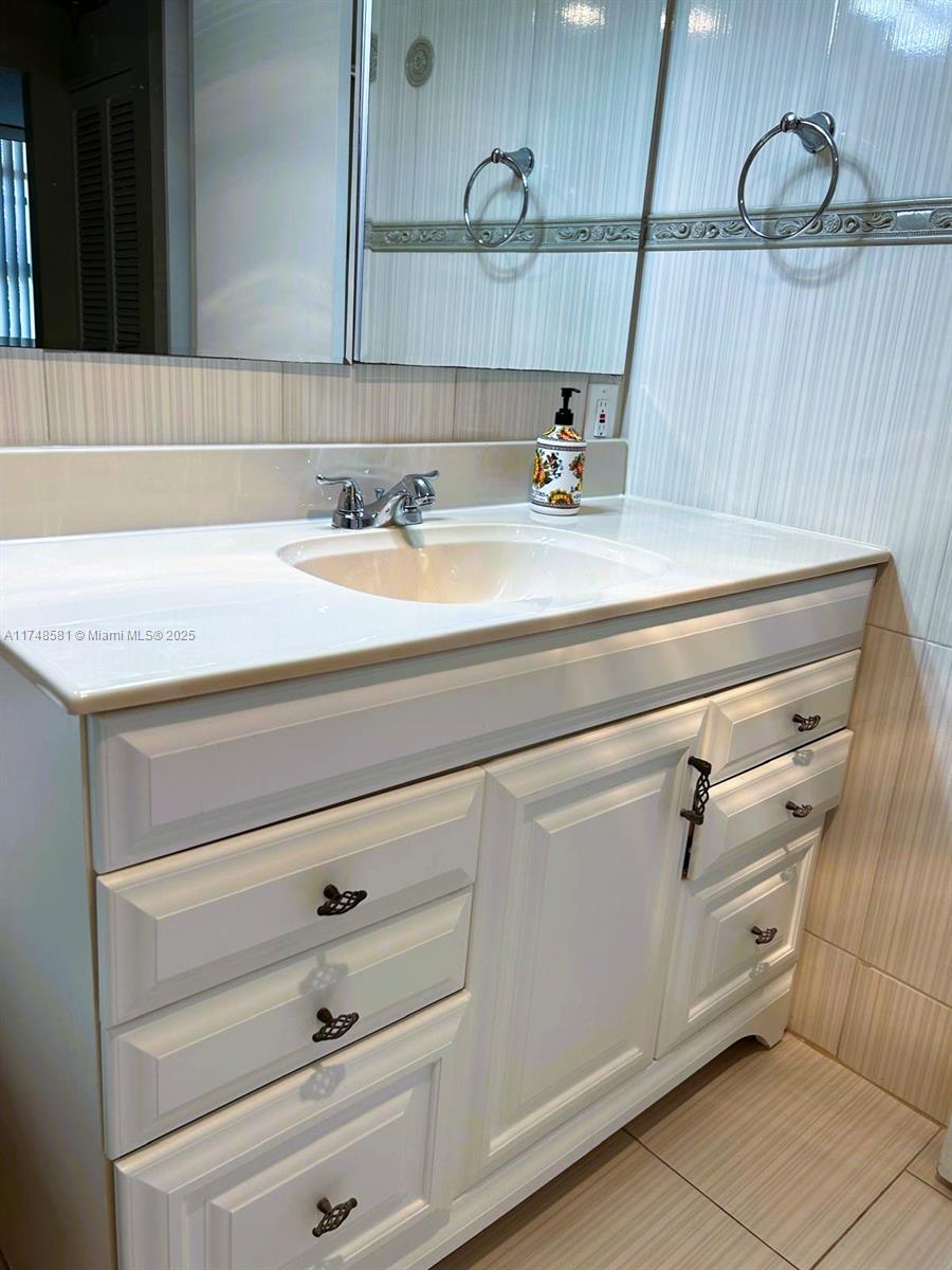 942 Northeast 199th Street, Unit 3E Miami, FL 33179 - Photo 12 of 31 a bathroom with a sink and a mirror
