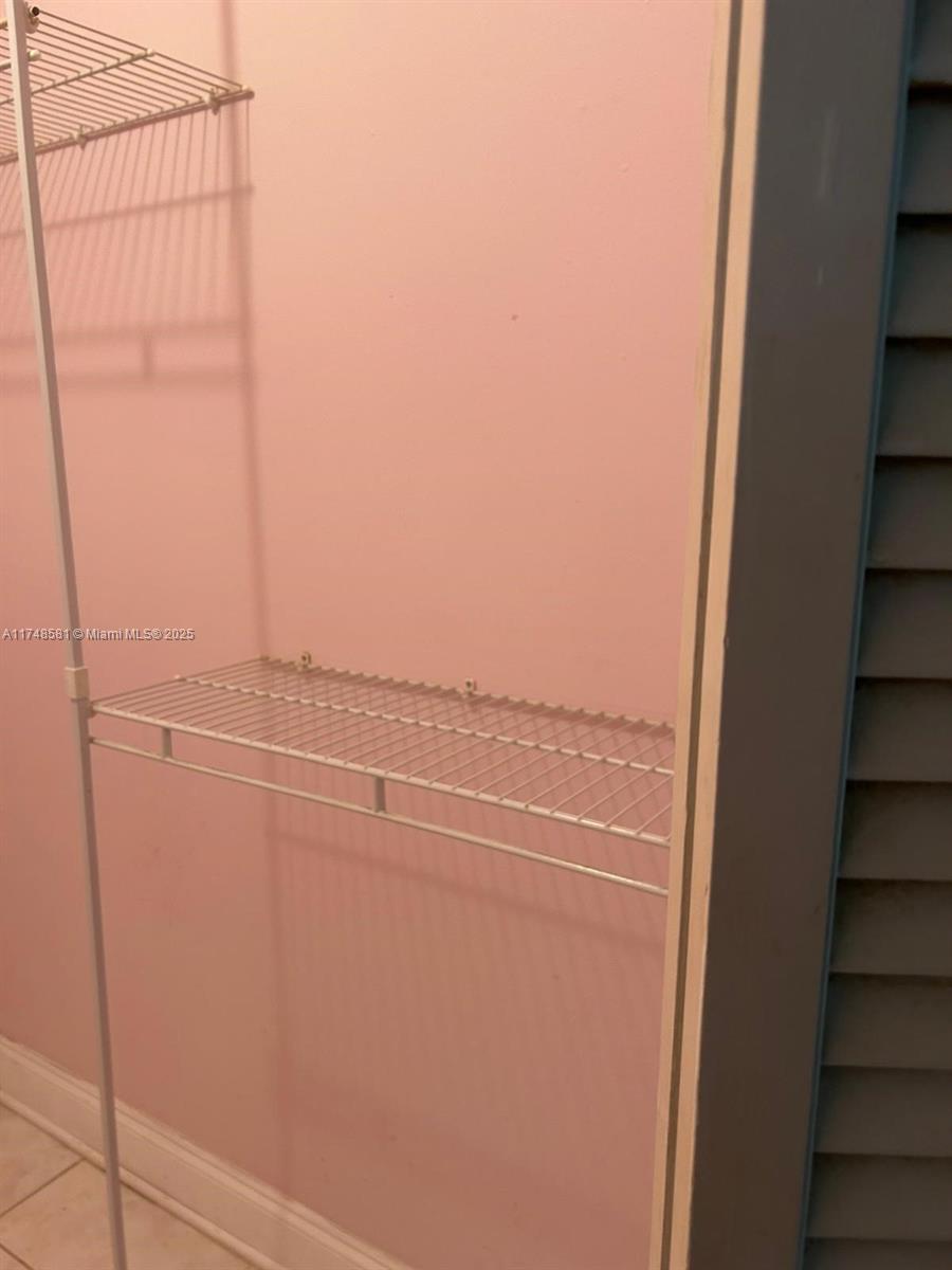 942 Northeast 199th Street, Unit 3E Miami, FL 33179 - Photo 15 of 31 a view of a room with racks on the wall