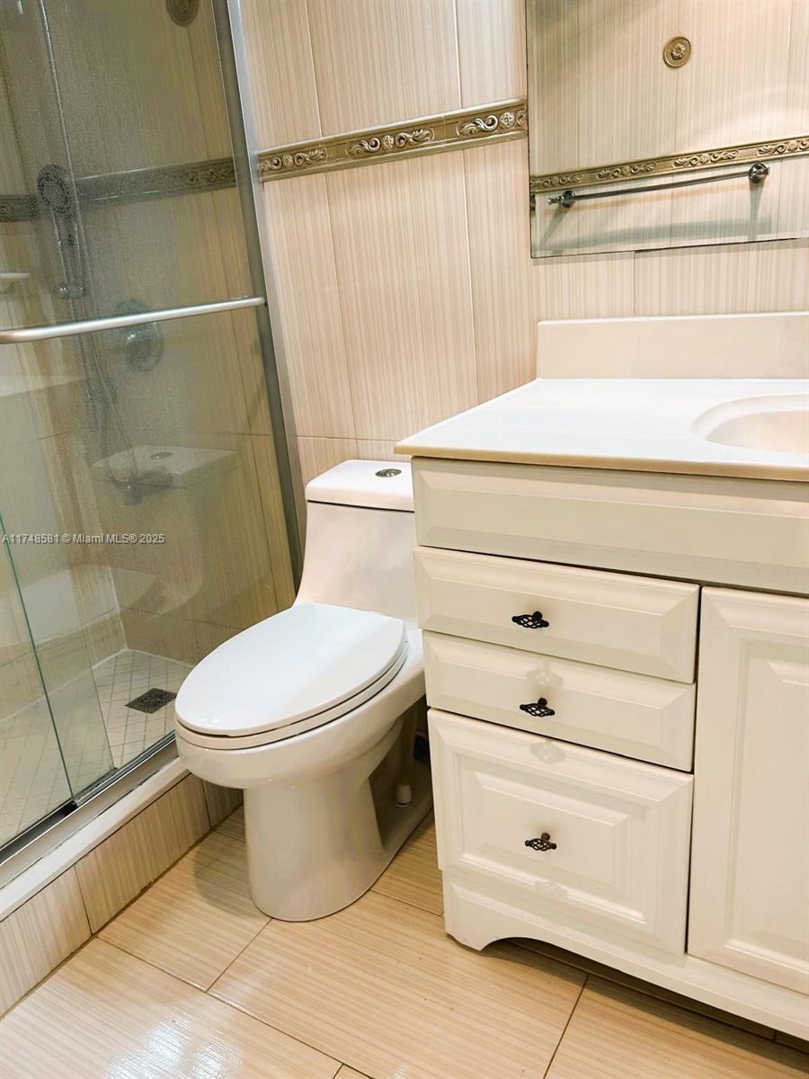 942 Northeast 199th Street, Unit 3E Miami, FL 33179 - Photo 16 of 31 a bathroom with a toilet and a shower