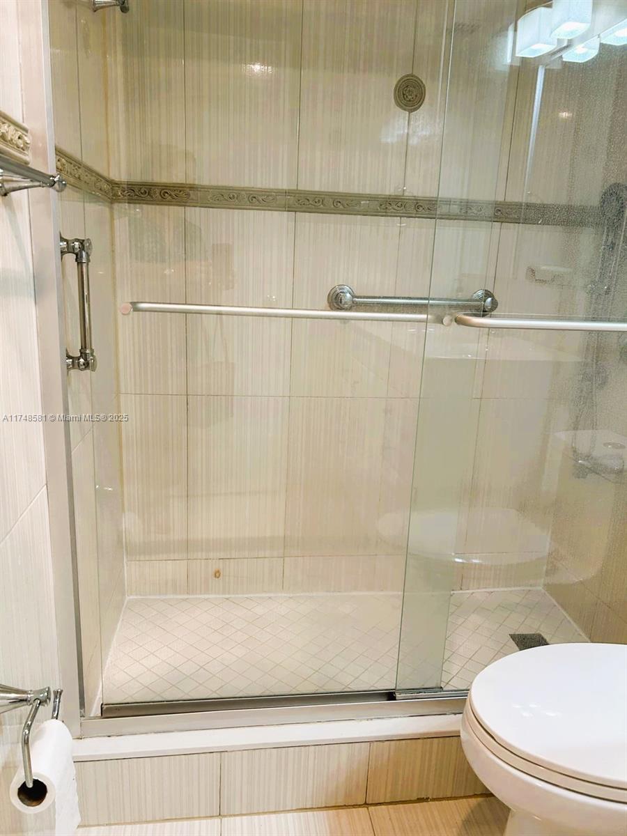 942 Northeast 199th Street, Unit 3E Miami, FL 33179 - Photo 17 of 31 a bathroom with a shower and a toilet