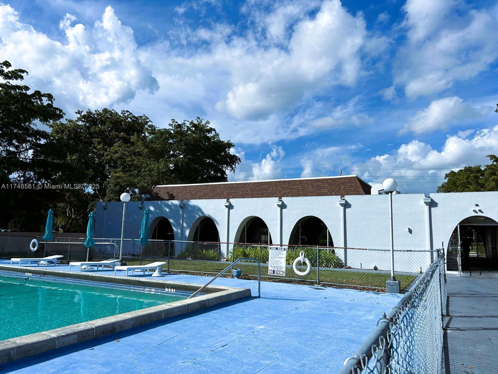 942 Northeast 199th Street, Unit 3E Miami, FL 33179 - Photo 27 of 31 a view of a house with backyard and roof