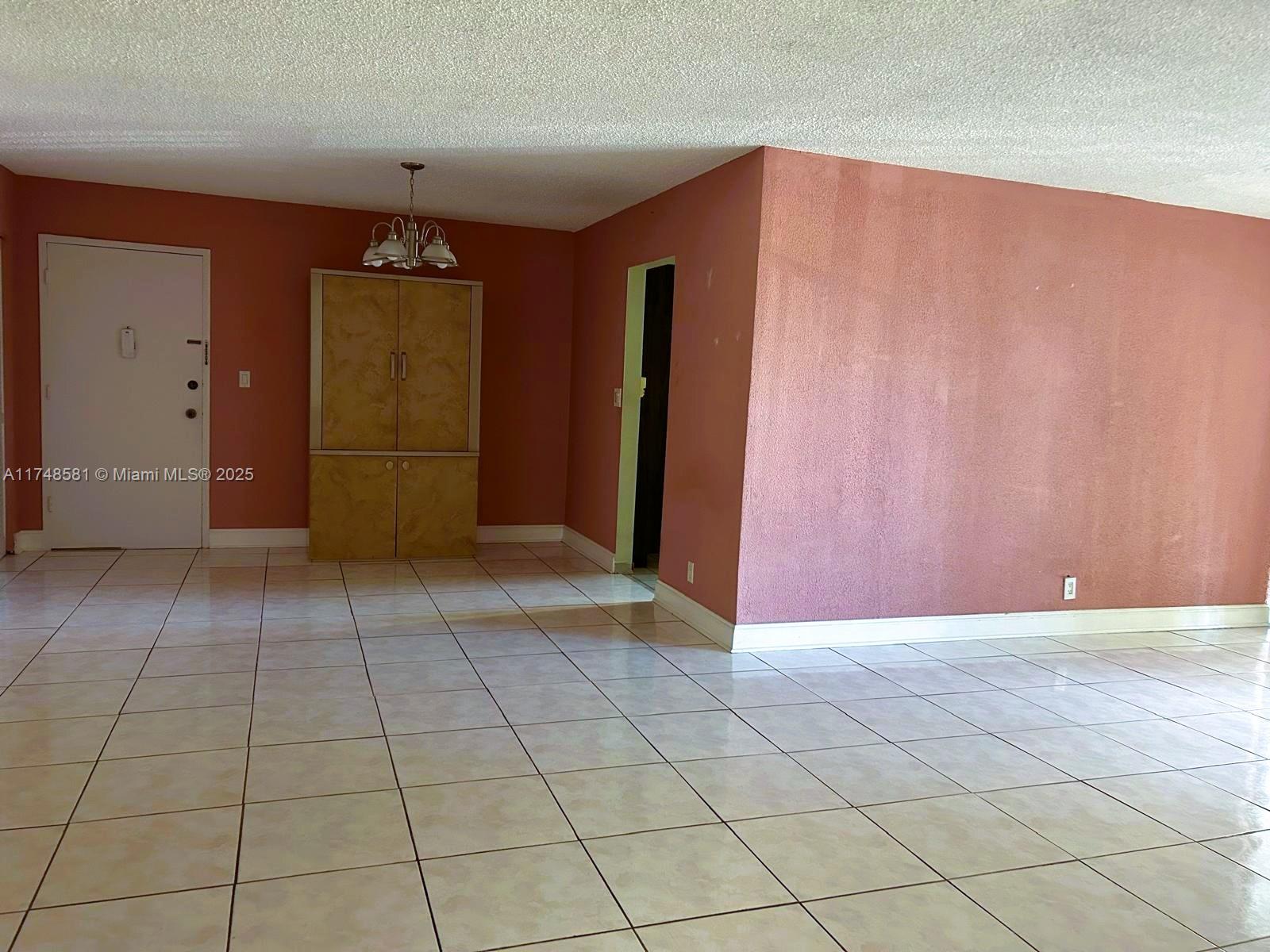 942 Northeast 199th Street, Unit 3E Miami, FL 33179 - Photo 7 of 31 a view of a livingroom with an empty space and a window