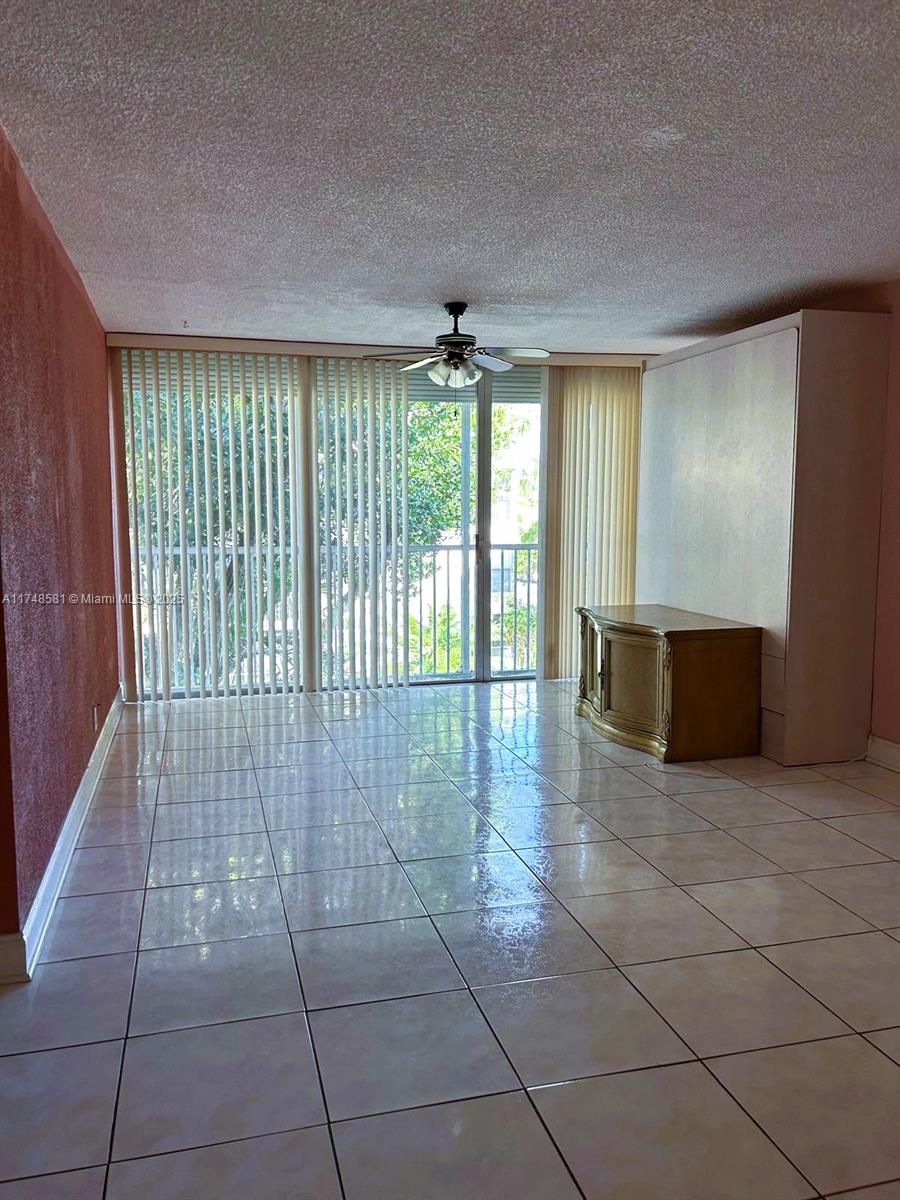 942 Northeast 199th Street, Unit 3E Miami, FL 33179 - Photo 8 of 31 a view of a hallway with a chandelier and living room