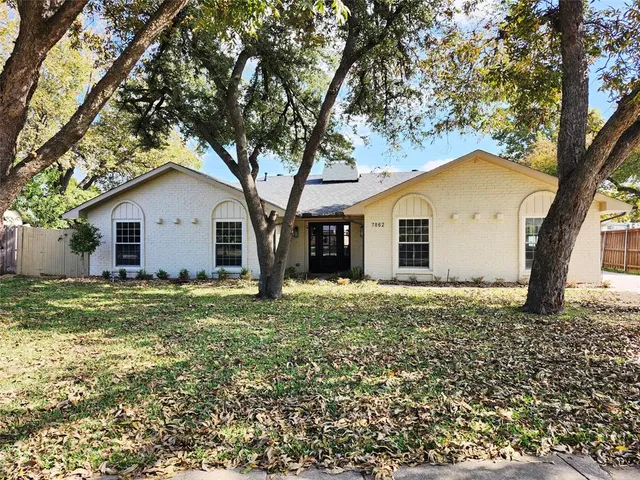 a large tree in front of a house with a large tree