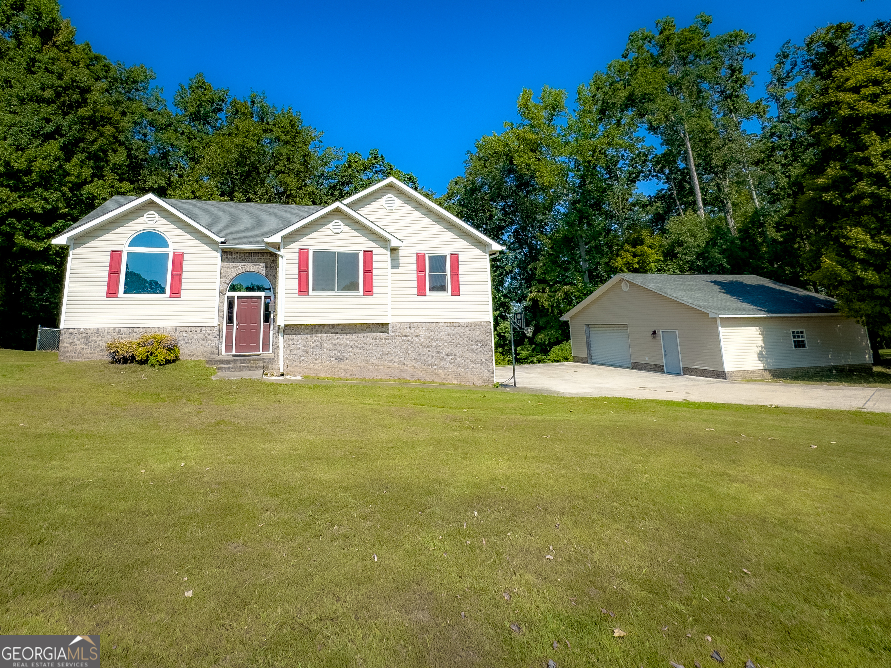 a front view of house with yard and trees in the background