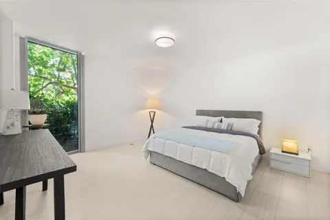 a bedroom with a bed and a lamp next to a window