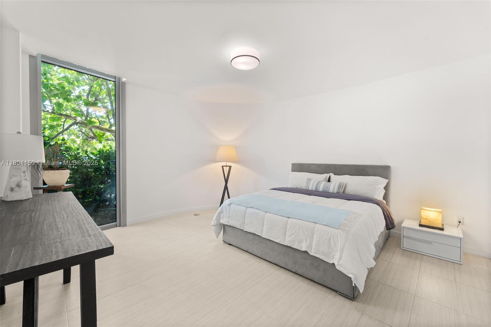 1 Collins Avenue, Unit 108 Miami Beach, FL 33139 - Photo 9 of 34 a bedroom with a bed and a lamp next to a window