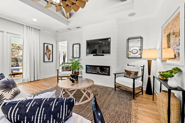 a living room with furniture a chandelier and a dining table with wooden floor