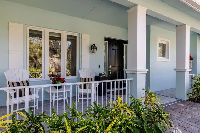 a large living room with wooden floor and chandelier