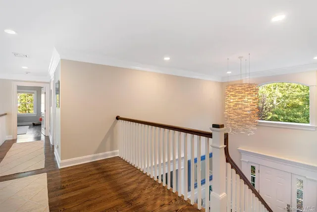 a view of hallway with a window and wooden floor