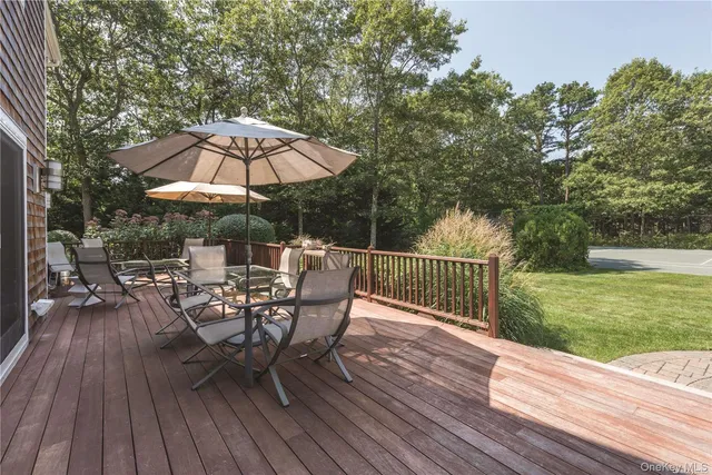 a view of deck with furniture and umbrella