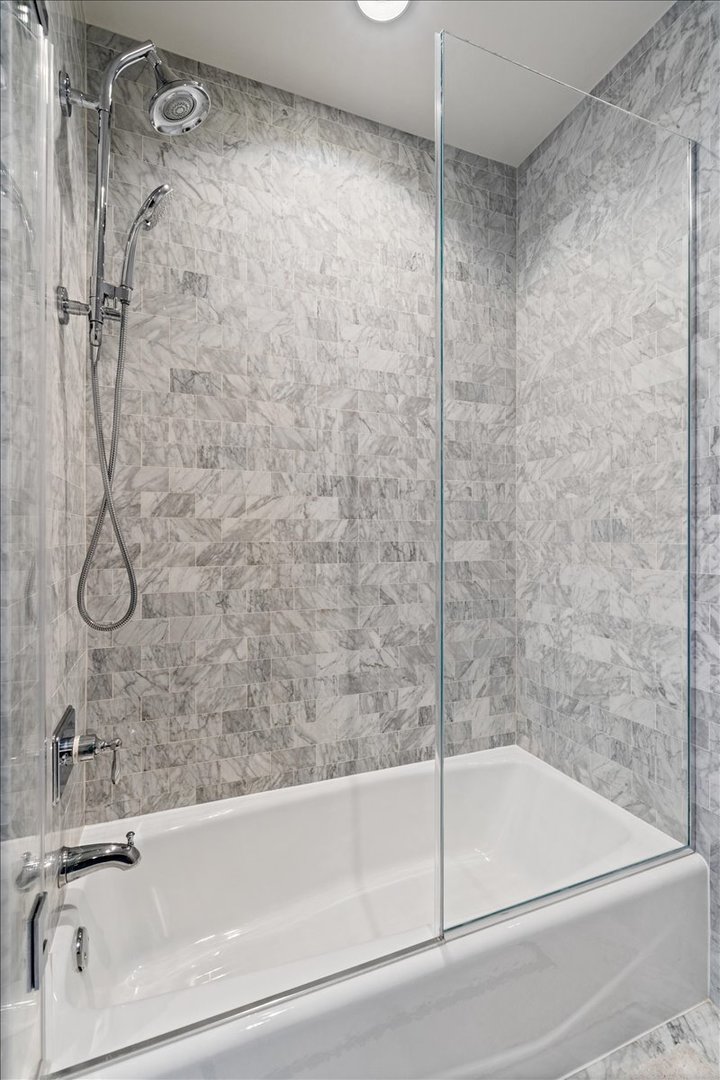10 East Delaware Place, Unit 28E Chicago, IL 60611 - Photo 27 of 41 a bathroom with a bathtub and a shower