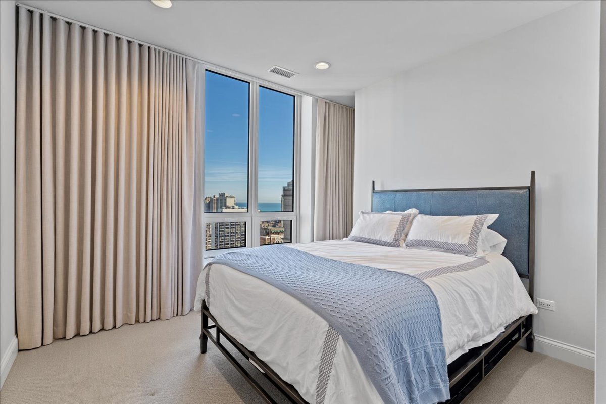 10 East Delaware Place, Unit 28E Chicago, IL 60611 - Photo 28 of 41 a large bed sitting in a bedroom next to a lamp