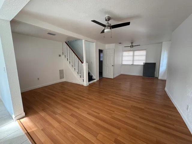a view of a livingroom with wooden floor and a ceiling fan