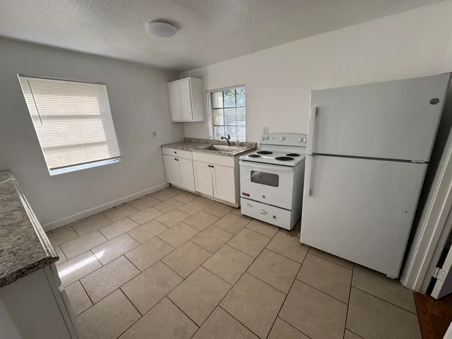 a kitchen with a refrigerator sink stove and cabinets