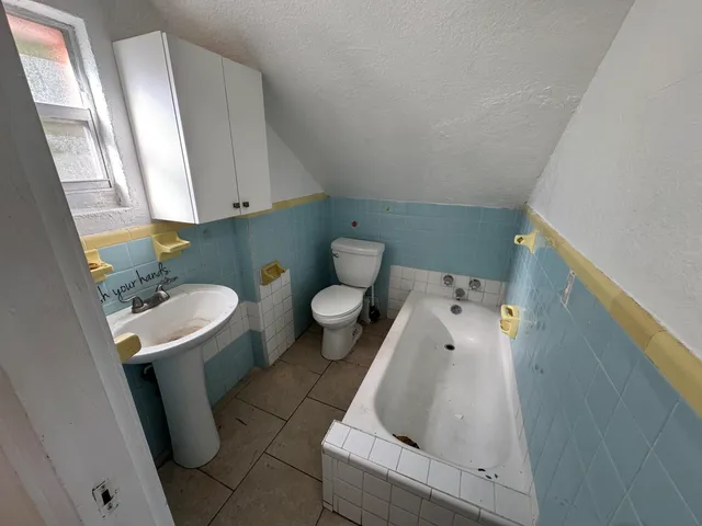 a bathroom with a sink toilet and mirror