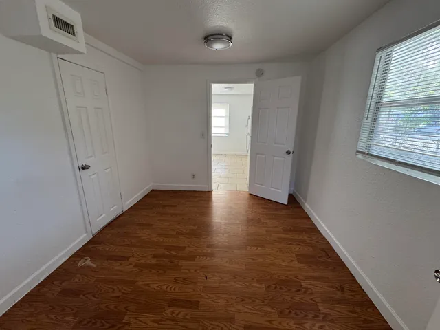 a view of a hallway with wooden floor and a window