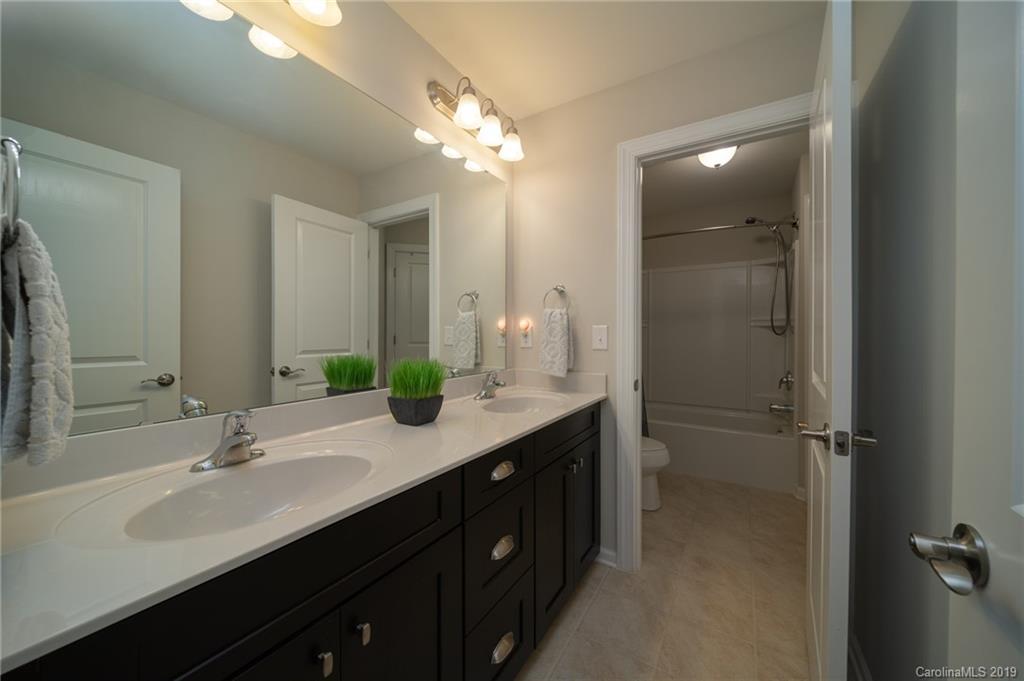 1002 Archibald Avenue Fort Mill, SC 29708 - Photo 22 of 26 a bathroom with a double vanity sink a mirror and a shower
