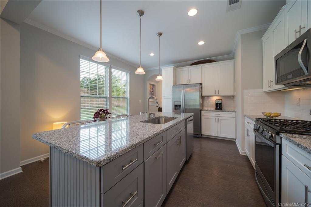 1002 Archibald Avenue Fort Mill, SC 29708 - Photo 10 of 26 a kitchen with kitchen island granite countertop stainless steel appliances a sink a stove and cabinets