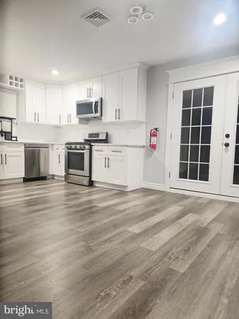 a kitchen with granite countertop a stove a sink and a refrigerator