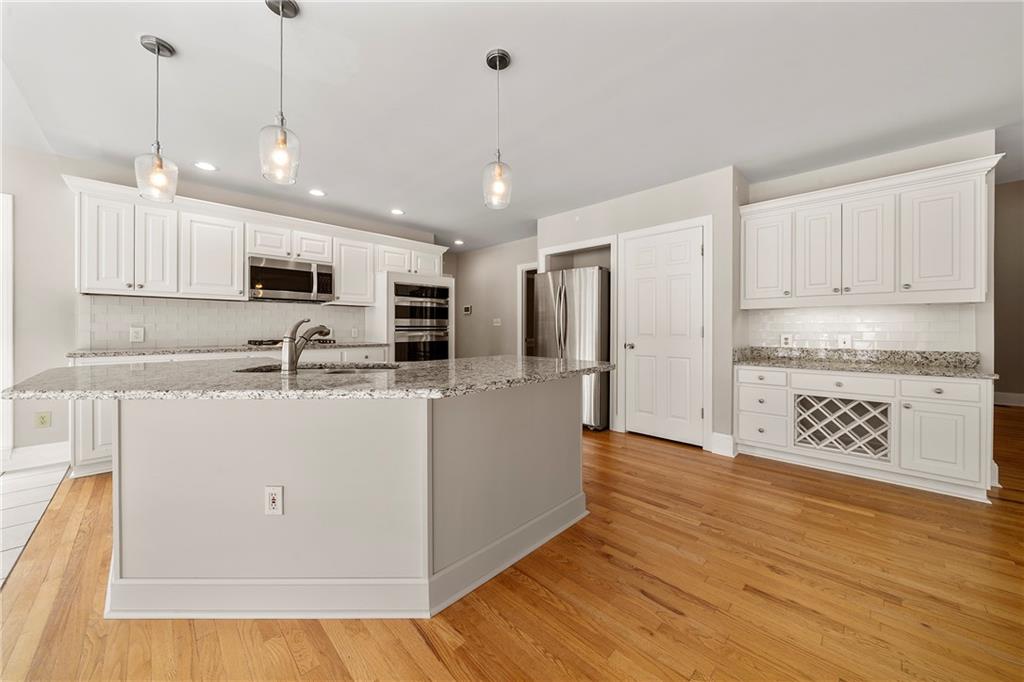 75 Spring Ridge Court Newnan, GA 30265 - Photo 19 of 75 a view of kitchen with stainless steel appliances granite countertop a refrigerator a oven a sink and white cabinets with wooden floor