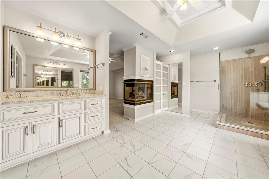75 Spring Ridge Court Newnan, GA 30265 - Photo 44 of 75 a bathroom with a sink a mirror and a shower