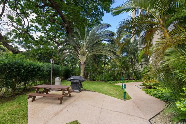a view of a park with a bench and trees