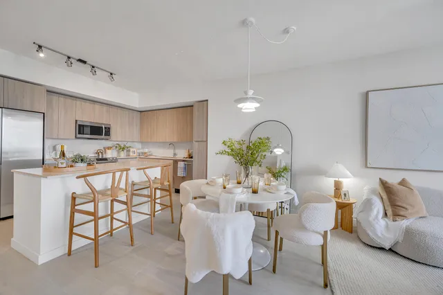 a kitchen with stainless steel appliances kitchen island granite countertop a table and chairs