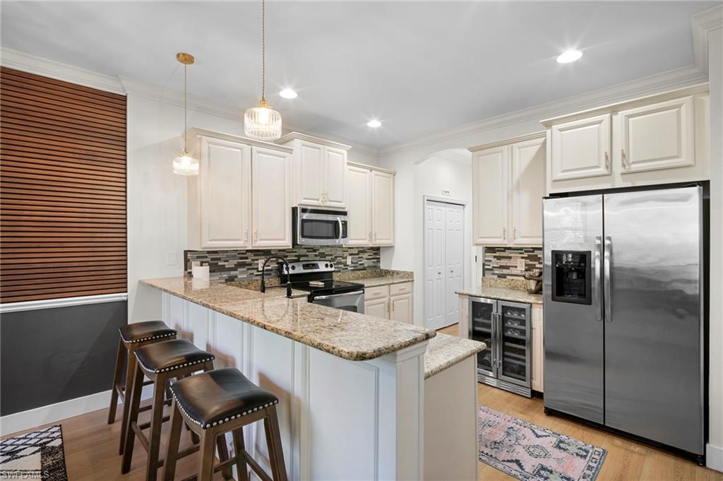 19501 Bowring Park Road, Unit 102 Fort Myers, FL 33967 - Photo 10 of 33 a kitchen with stainless steel appliances a stove a sink island and a refrigerator