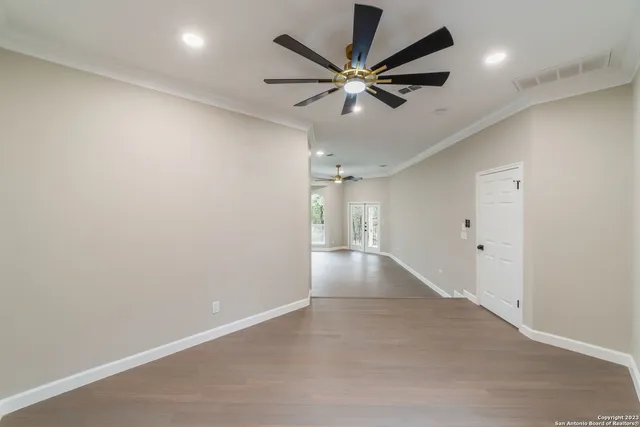 an empty room with a ceiling fan and a fan