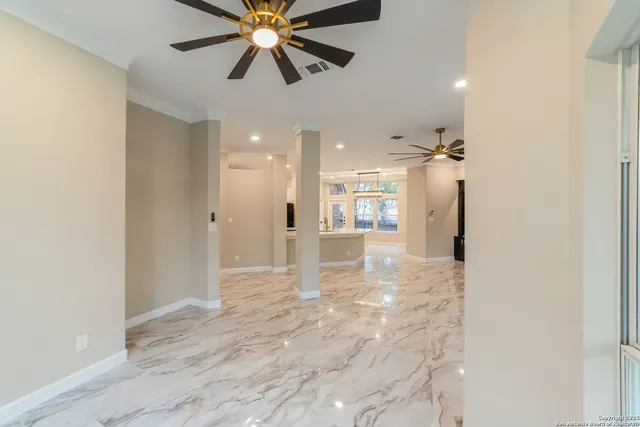 a view of an empty room and kitchen view
