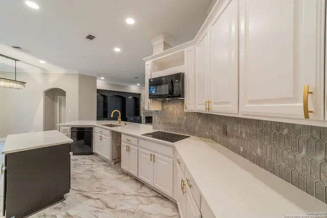 a kitchen with granite countertop a sink and cabinets