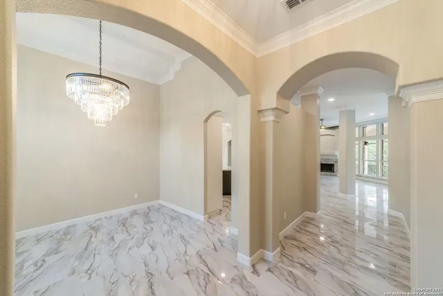 a view of a hallway with wooden floor and a chandelier