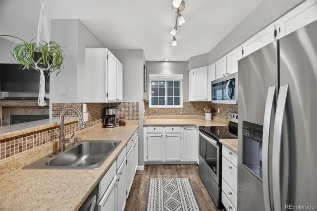 a kitchen with a sink refrigerator and cabinets