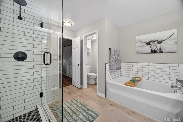 a bathroom with a tub a sink a mirror and shower