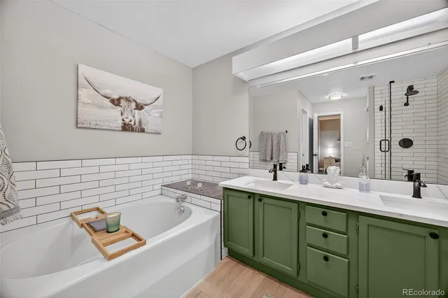 a bathroom with a tub a sink and mirror