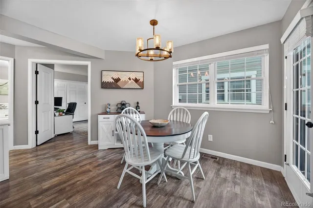 a dining room with furniture a chandelier and wooden floor