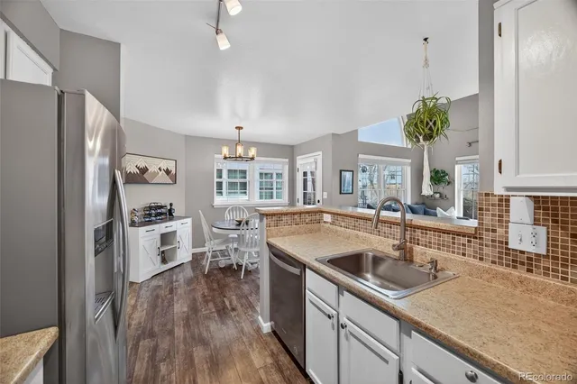 a kitchen with a sink a counter top space stainless steel appliances and a window