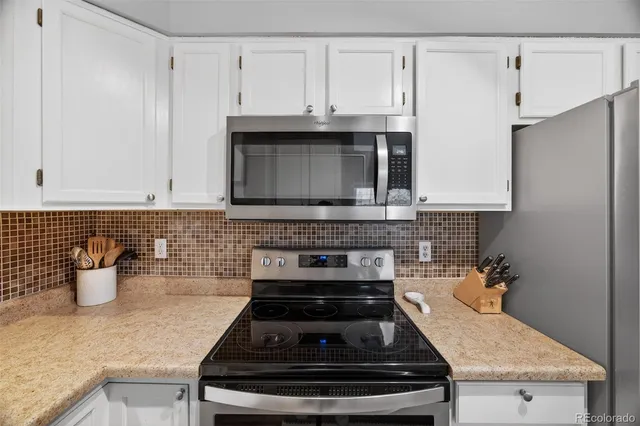 a kitchen with stainless steel appliances granite countertop a stove a microwave and cabinets