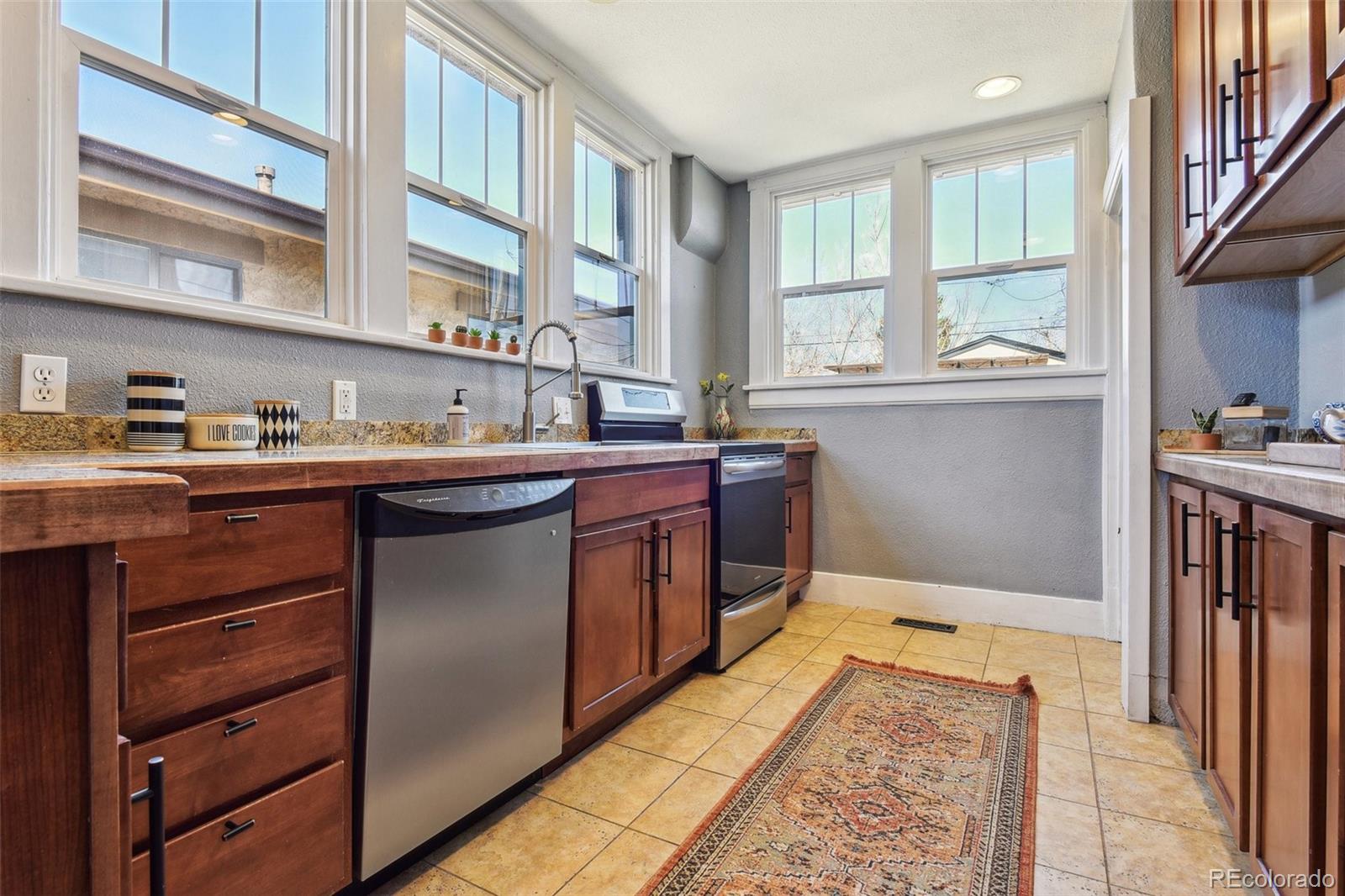 3946 Perry Street Denver, CO 80212 - Photo 8 of 27 a kitchen with a sink stove and cabinets