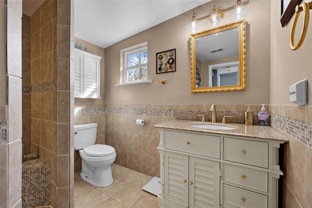 3130 Southwest 86th Way Bell, FL 32619 - Photo 14 of 52 a bathroom with a granite countertop toilet sink and mirror