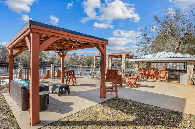 a view of a patio with dining table and chairs with wooden fence