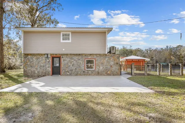 a view of a house with backyard and sitting area