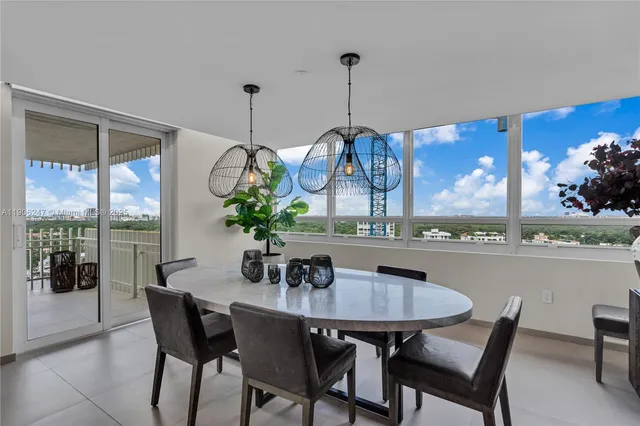 a dining room table with chairs and potted plants