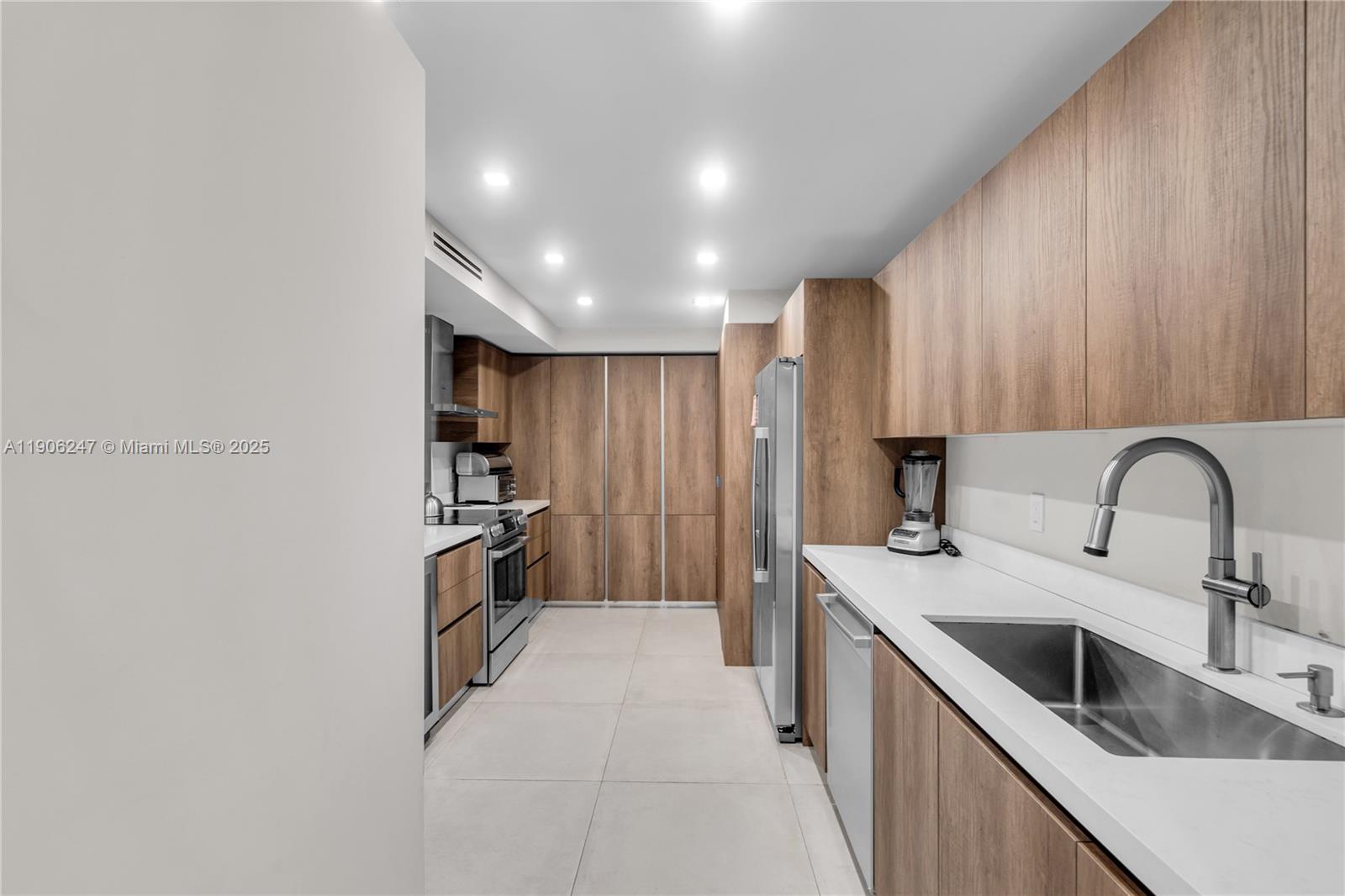 3 Grove Isle Drive, Unit C1710 Miami, FL 33133 - Photo 16 of 37 a kitchen with kitchen island a sink appliances and cabinets