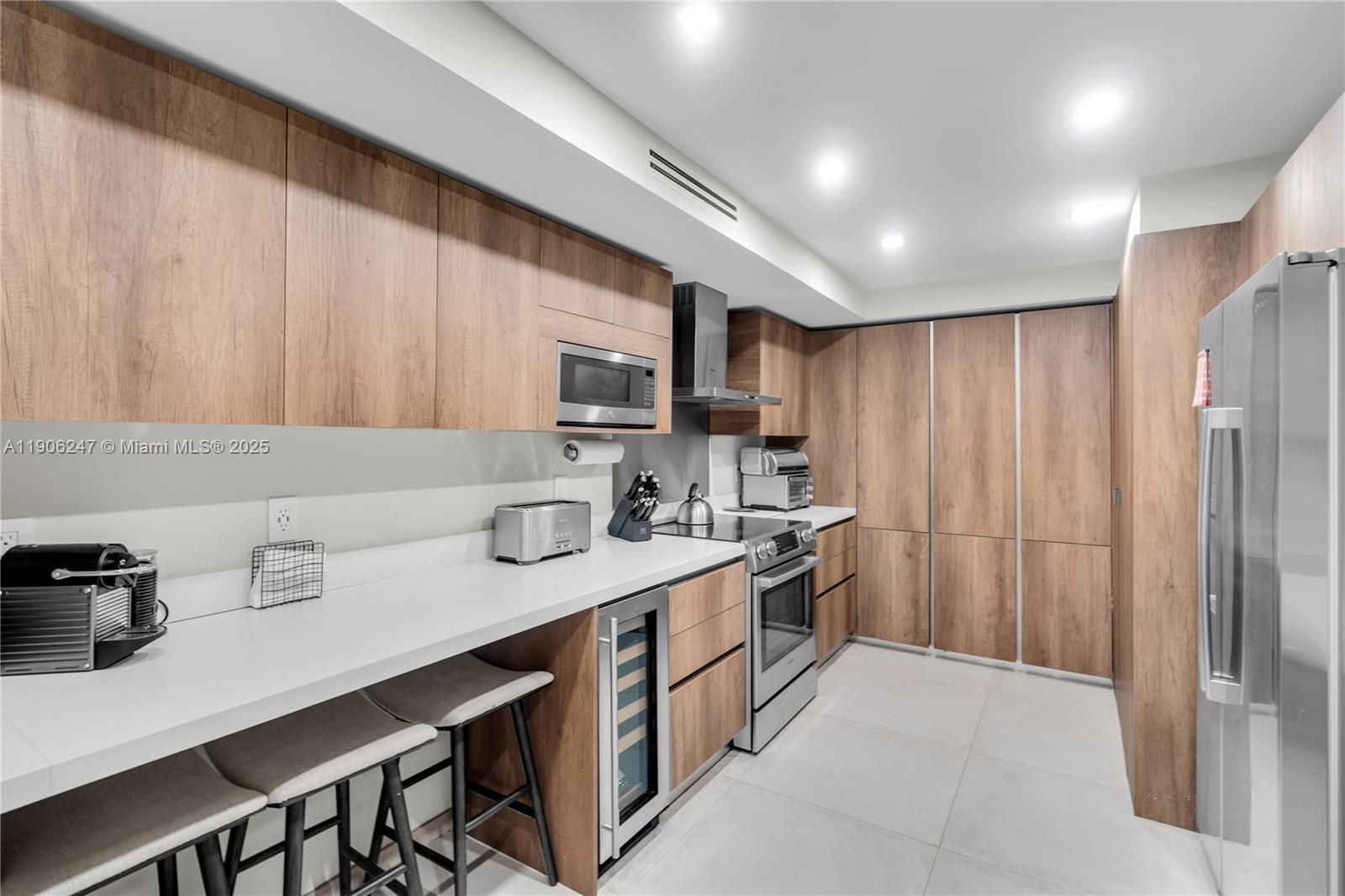 3 Grove Isle Drive, Unit C1710 Miami, FL 33133 - Photo 18 of 37 a kitchen with stainless steel appliances a sink a stove a refrigerator cabinets and a counter top space